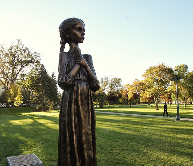 Statue de bronze d'une petite fille tenant du blé sur sa poitrine commémorant l'Holodomor, devant l'édifice de l'Assemblée législative du Manitoba, à Winnipeg